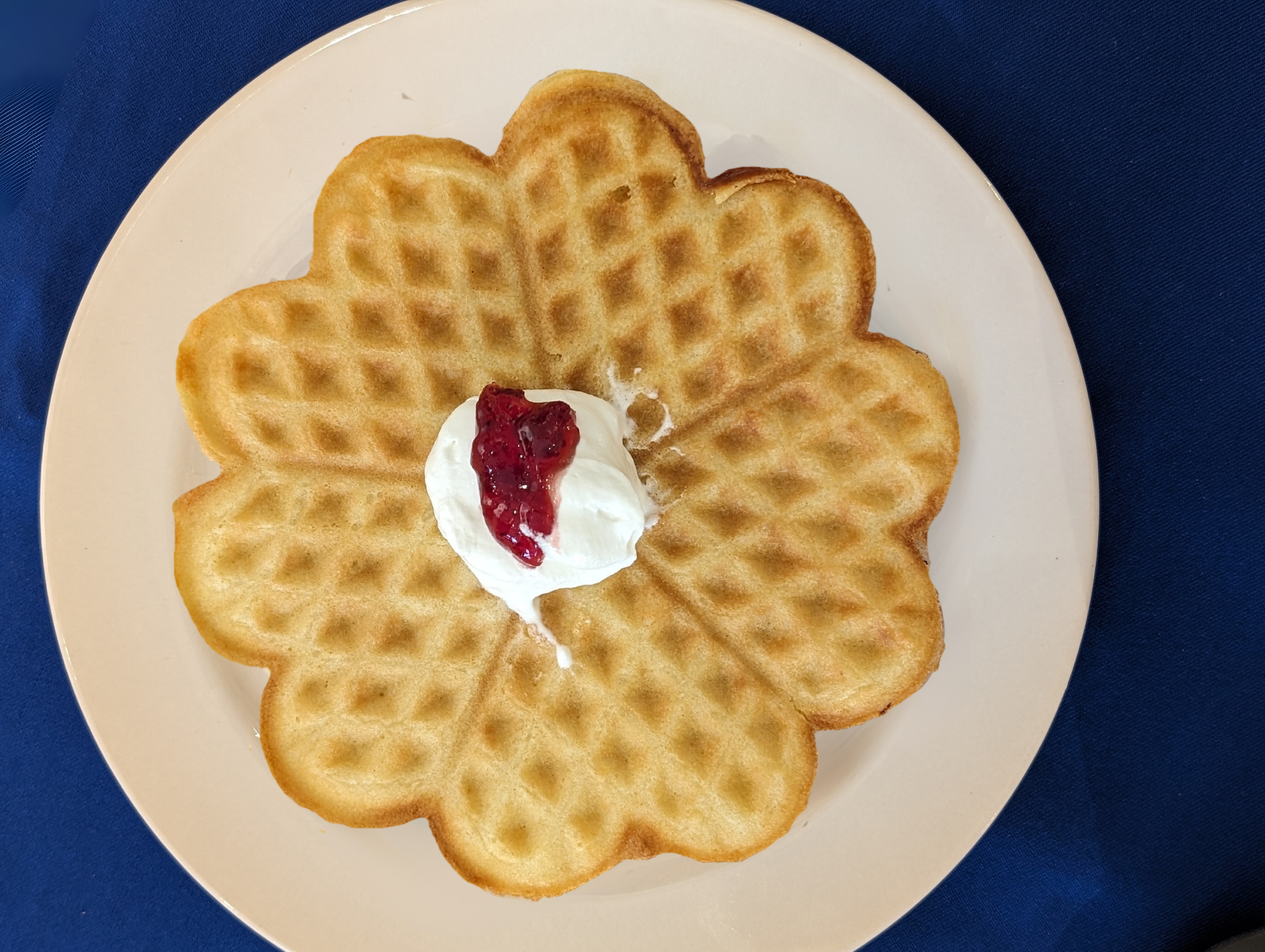 Flower-shaped waffle with jam and cream